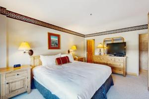 a bedroom with a large bed and a flat screen tv at Shoshone 1930 in Big Sky +41 photos