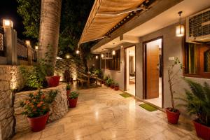 an outdoor patio with potted plants and a restaurant at Peach stay in Mount Ābu