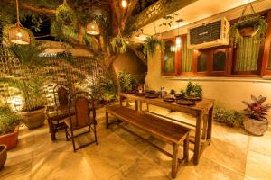 a wooden table and bench in a room with a tree at Peach stay in Mount Ābu