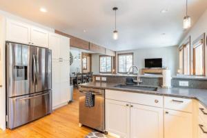 a kitchen with white cabinets and a stainless steel refrigerator at Fox Trail in Columbia Falls