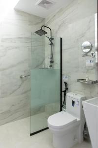 a bathroom with a toilet and a glass shower at هوليدي الخليج الفندقية Holiday Alkhaleej in Riyadh +24 photos