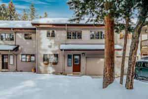 a house with a garage in the snow at The Hip Rose in Big Sky