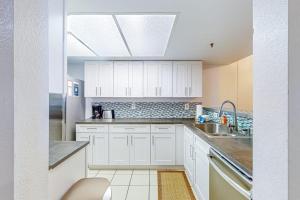 a kitchen with white cabinets and a sink at The Bridges 102 in Mammoth Lakes