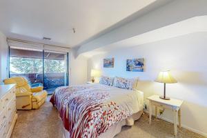 a bedroom with a bed and a chair and a window at The Bridges 102 in Mammoth Lakes