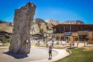 a group of people standing next to a rock wall at The Bridges 102 in Mammoth Lakes
