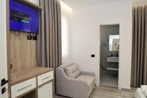 a living room with a chair and a tv in a room at Darius Hotel in Shkodër +33 photos