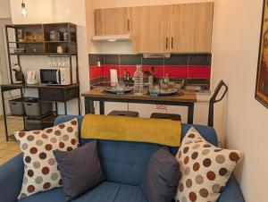 a living room with a blue couch and a kitchen at L'Aiglon Studio cocon au coeur de Gap in Gap +15 photos