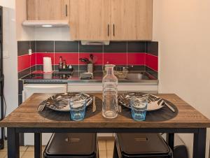 a kitchen with a table with glasses and a bottle at L'Aiglon Studio cocon au coeur de Gap in Gap