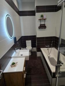 a bathroom with a sink and a tub and a toilet at Arzella Beachfront Guesthouse in Birżebbuġa +31 photos