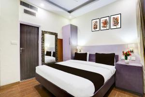 a hotel room with a large bed and a mirror at Townhouse by OYO Brahma Sarovar Formerly Krishna mahal in Kurukshetra