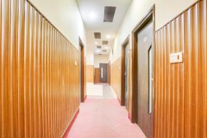a corridor of a hallway with wooden walls and doors at Townhouse by OYO Brahma Sarovar Formerly Krishna mahal in Kurukshetra