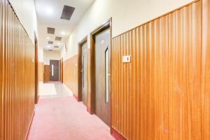a hallway with wooden walls and doors in a building at Townhouse by OYO Brahma Sarovar Formerly Krishna mahal in Kurukshetra