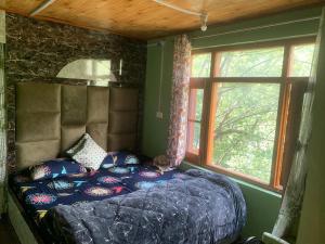 a bedroom with a bed with pillows and a window at Crown royal shahjee stay in Rezan