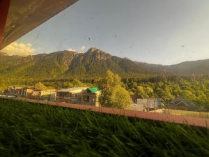 a train on a track with mountains in the background at Crown royal shahjee stay in Rezan +12 photos