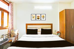 a bedroom with a large bed with a wooden headboard at Hotel O by OYO Sector 45 Formerly Manyavar in Chandīgarh