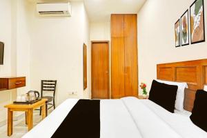 a bedroom with a bed and a table and a chair at Hotel O by OYO Sector 45 Formerly Manyavar in Chandīgarh +24 photos