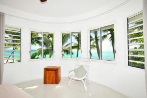 a white room with windows and a chair and a table at Villa Eva in Belle Mare