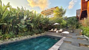 a swimming pool in front of a house at Twinseas Villa in Uluwatu