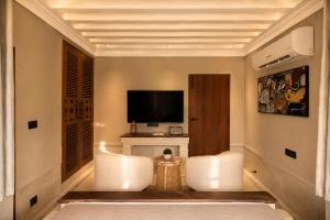 a living room with two chairs and a television at YAMA Villa Udaipur in Udaipur