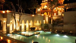 a swimming pool with lights in a building at night at YAMA Villa Udaipur in Udaipur