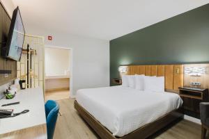 a hotel room with a large bed and a desk at SureStay by Best Western Morgan Hill in Morgan Hill