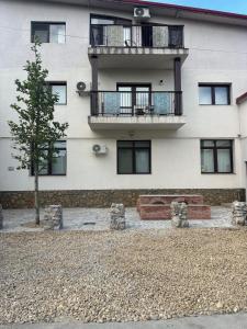 a building with a tree in front of it at Apartament Magurele spatios cu intrare separata in Măgurele
