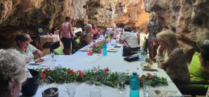 a group of people sitting around a long table at Cave House in Kilifi