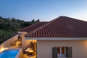 a view of a house with a swimming pool at Anthos Villa in Kardhakáta