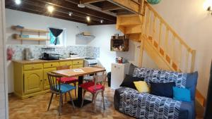a living room with a table and a kitchen at Le chalet des paons - Le Mond'idéal in Felon +32 photos