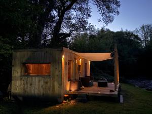 a small wooden cabin with a tent on a deck at Nesta's Nook in Llandovery