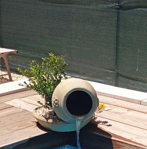a pot with a plant sitting on a wooden deck at Ulivo Apartment in Ragusa