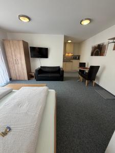 a hotel room with a bed and a living room at Apartments Am Grafenberg in Grafenberg