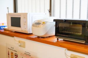 a microwave and a toaster oven on a counter at UMICHIKA AOSHIMA - Private house 一棟貸し in Miyazaki
