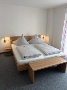 a bed with two pillows on it in a room at Apartments Am Grafenberg in Grafenberg