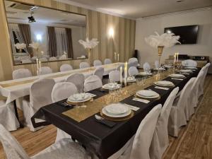 a long dining room with a long table and white chairs at NOVA Motel in Międzyrzecz