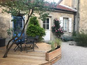 a wooden deck with a table and chairs in front of a house at La Rotonde in Poligny