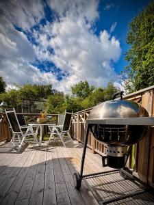 a grill on a deck with a table and chairs at Photoeverhome in Bengtsfors