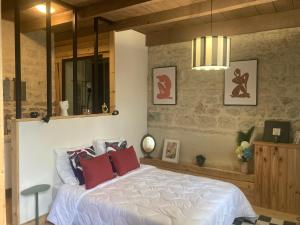 a bedroom with a large white bed with red pillows at La Rotonde in Poligny