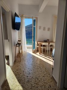 a living room with a view of a table and a television at Big apartment on the beach in Tolo