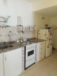 a kitchen with a stove and a refrigerator at Tu hogar en Concordia in Concordia