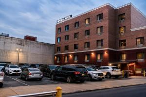 a parking lot with cars parked in front of a building at Imperial Hotel Brooklyn New in Brooklyn