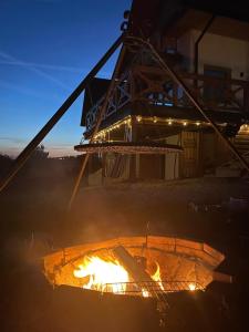 a fire pit with a building in the background at Hubacówka in Huba