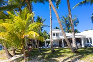 a house on the beach with palm trees at Villa Eva in Belle Mare