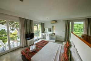 a bedroom with a large bed and a balcony at La Moda Beach Hotel in Kaş