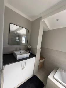 a bathroom with a sink and a mirror at Prime location in Welgemoed in Welgemoed +20 photos