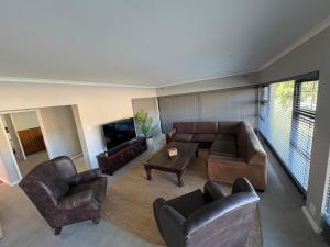 a living room with a couch and chairs and a tv at Prime location in Welgemoed in Welgemoed