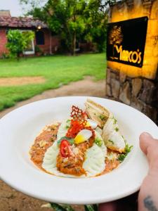 a person holding a white plate with food on it at Shannu's Ranch Inn in Pushkar