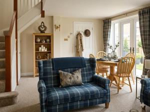 a living room with a blue couch and a table at Coach House Hideaway in Warminster