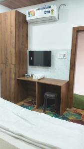 a room with a desk with a computer and a bed at Mark inn hotel in Hanumāngarh