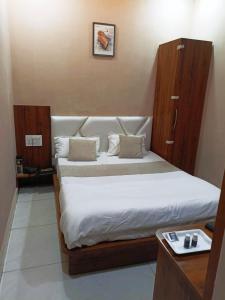 a bedroom with a large bed with white sheets at Mark inn hotel in Hanumāngarh